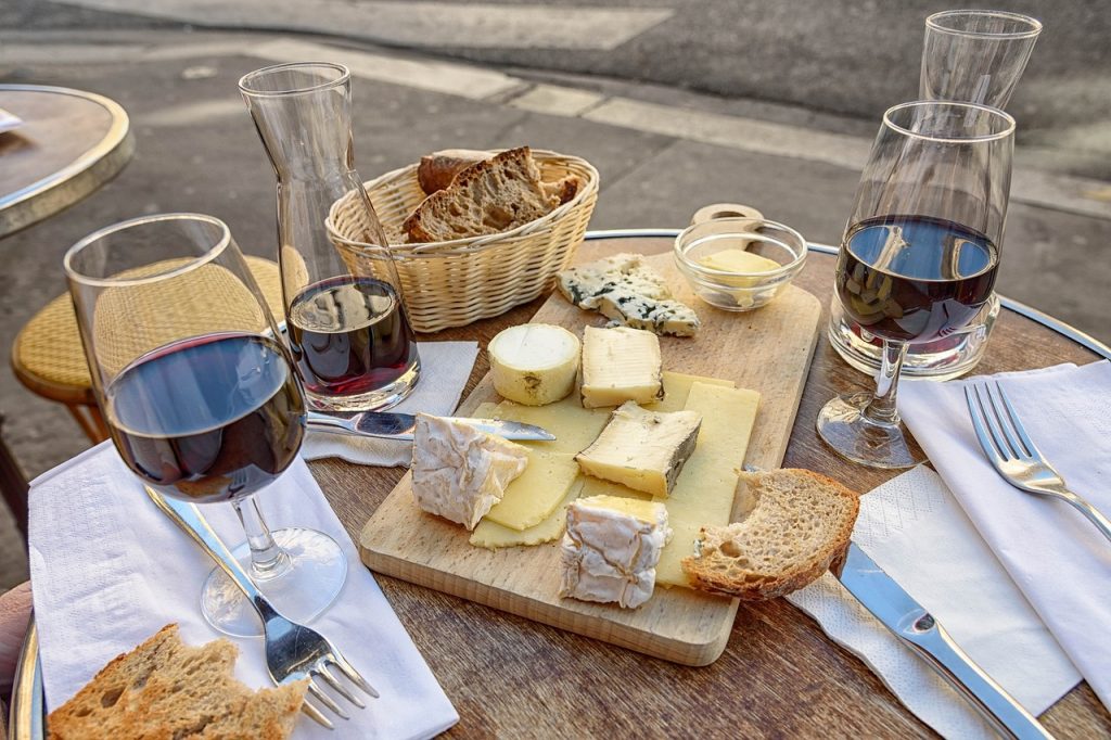 Variedad de quesos acompañados de dos copas de vino